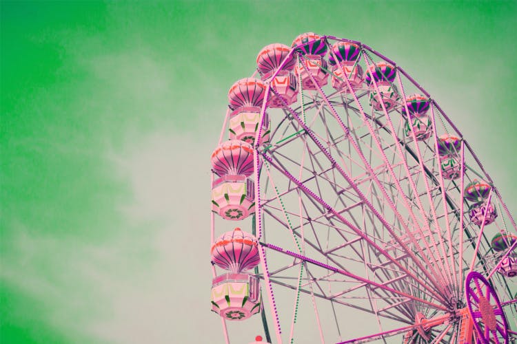 pink tinted ferris wheel against green sky